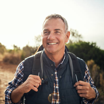 smiling grey haired man hiking